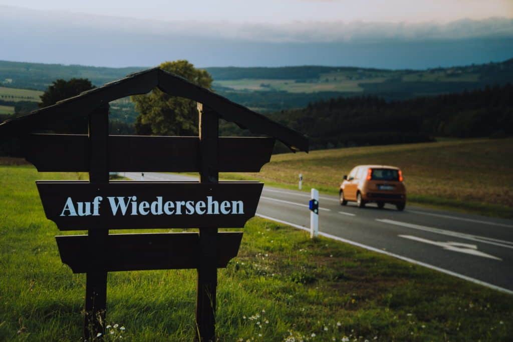 Ein Holzschild neben einer Straße sagt "Auf Wiedersehen". Ein Symbolbild für das Thema Kündigung des Arbeitsvertrages: Rechte, Pflichten und Prozess